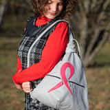 grey artisan leather backpack with a pink ribbon on shoulders of a woman