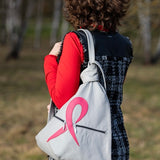 grey leather artisan backpack with pink ribbon on a shoudler of a woman