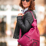 pink leather backpack on shoulders of a woman