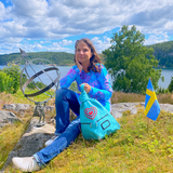 Blue Romantic Handmade Leather Backpack with Heart Details with woman on a rock in Sweden